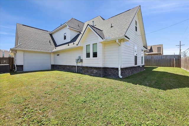 back of house featuring central air condition unit, a lawn, fence, roof with shingles, and an attached garage