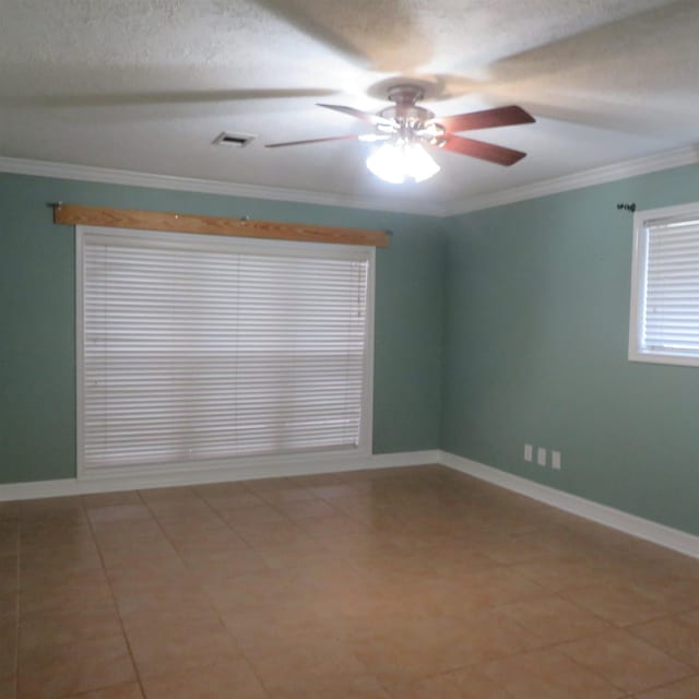 unfurnished room featuring ornamental molding, visible vents, ceiling fan, and baseboards