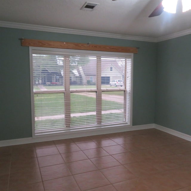 empty room with tile patterned flooring, visible vents, and crown molding