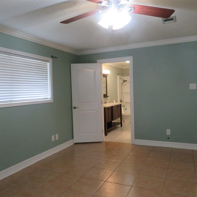 spare room with baseboards, visible vents, a ceiling fan, and ornamental molding