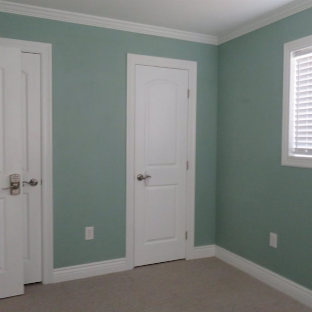 unfurnished bedroom featuring crown molding and baseboards