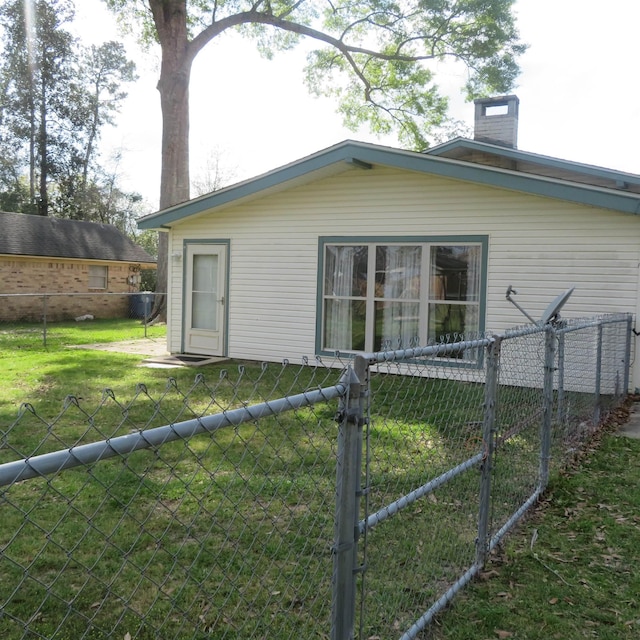 view of property exterior featuring a gate, a chimney, fence, and a yard