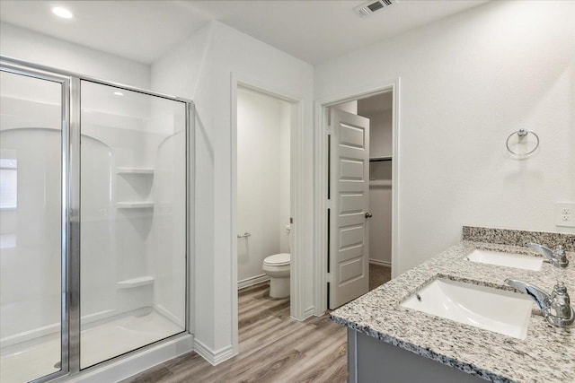 bathroom with vanity, wood-type flooring, an enclosed shower, and toilet