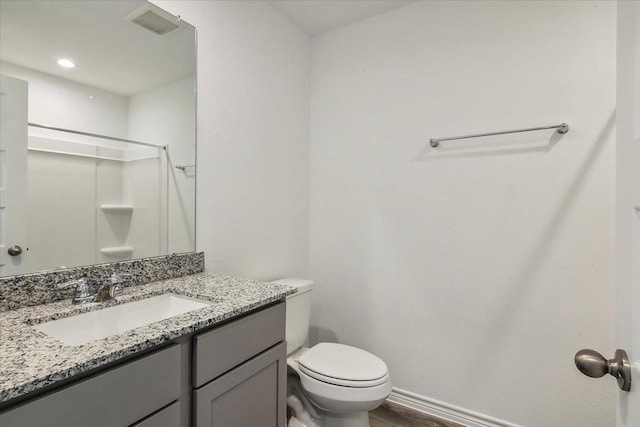 bathroom featuring a shower, hardwood / wood-style flooring, vanity, and toilet