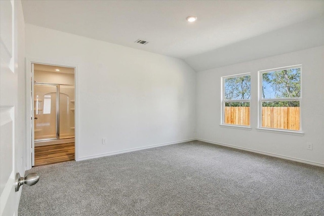 empty room featuring carpet flooring and vaulted ceiling