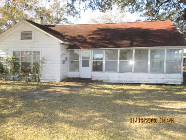 rear view of property with a yard