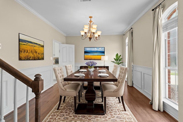 1424 Arbor Ct, Nederland, TX 77627 - dining area with wood finished floors, ornamental molding, a chandelier, wainscoting, and a decorative wall