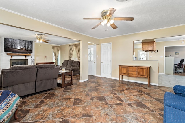 171 Ridgewood St, Bridge City, TX 77611 - living room with a ceiling fan, baseboards, a brick fireplace, ornamental molding, and a textured ceiling