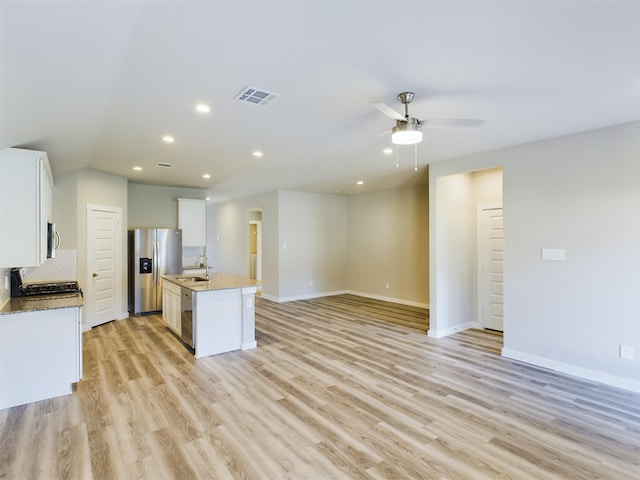 kitchen featuring sink, appliances with stainless steel finishes, a kitchen island with sink, white cabinets, and light wood-type flooring