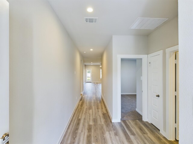 hallway with light hardwood / wood-style floors