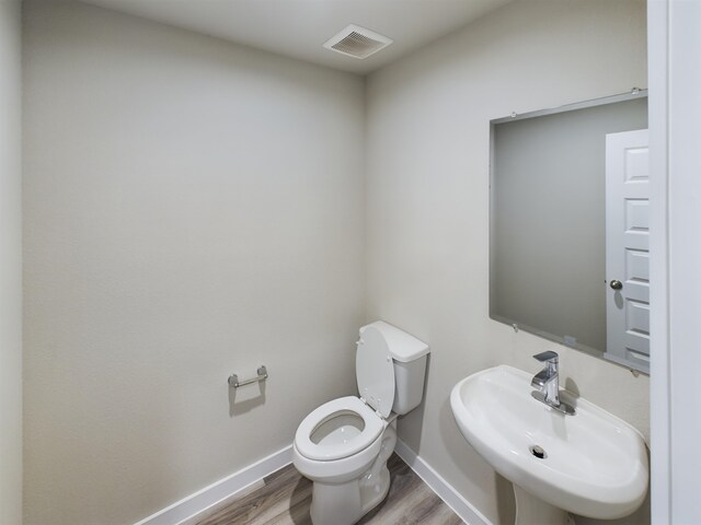 bathroom featuring hardwood / wood-style floors, toilet, and sink