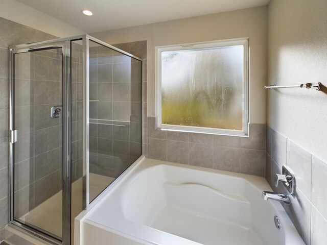 bathroom featuring shower with separate bathtub