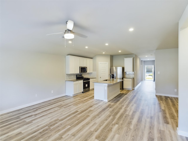 kitchen with white cabinets, an island with sink, light wood-type flooring, and appliances with stainless steel finishes