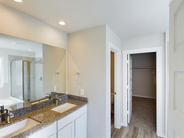 full bathroom with vanity, toilet, wood-type flooring, and independent shower and bath