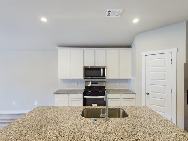 kitchen with appliances with stainless steel finishes, white cabinetry, and sink