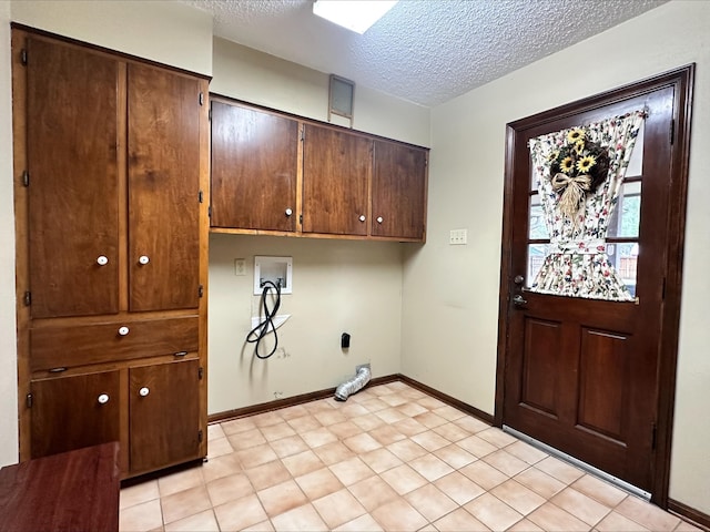 laundry area featuring washer hookup, electric dryer hookup, cabinets, and a textured ceiling