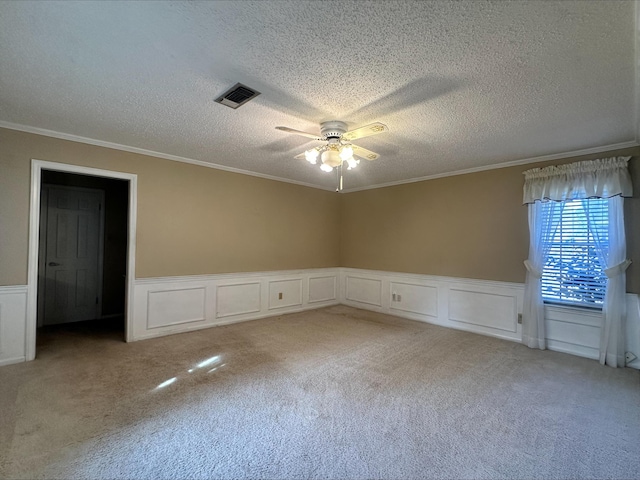 carpeted spare room with crown molding, a textured ceiling, and ceiling fan