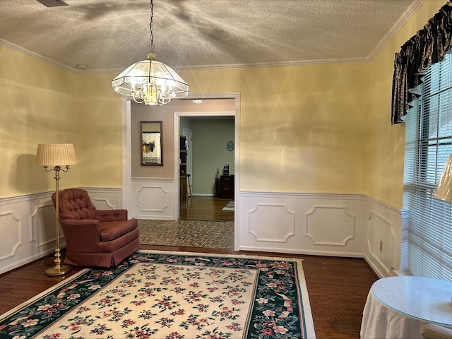 interior space featuring dark wood-type flooring, ornamental molding, a textured ceiling, and a notable chandelier