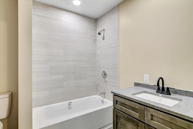 full bathroom featuring vanity, toilet, and tiled shower / bath