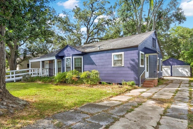 view of front facade featuring an outbuilding, a garage, and a front lawn