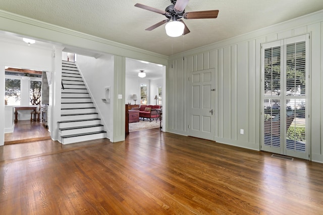 interior space featuring a textured ceiling, crown molding, ceiling fan, and dark wood-type flooring