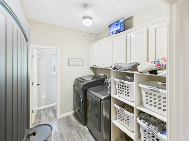 7090 Carroll Ln, Beaumont, TX 77713 - washroom featuring washer and dryer, cabinet space, and light wood-style flooring