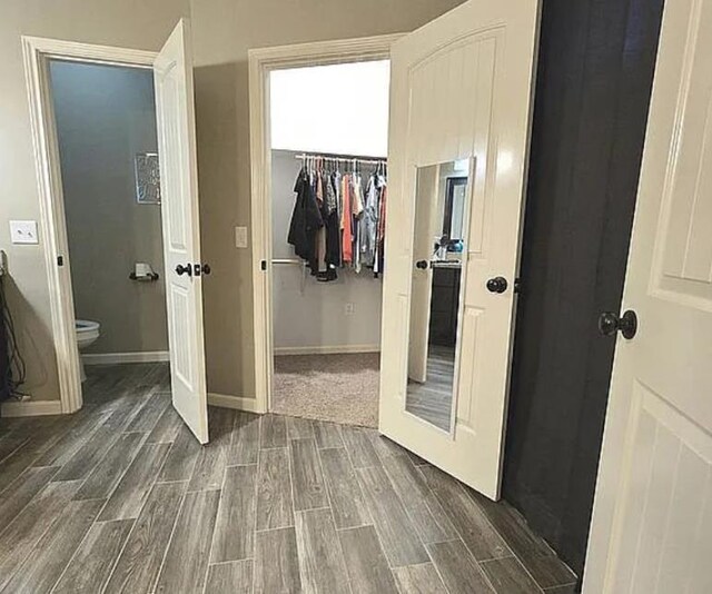 7090 Carroll Ln, Beaumont, TX 77713 - bedroom with wood tiled floors, a closet, a walk in closet, and baseboards