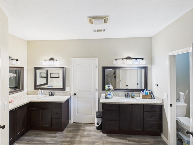 7090 Carroll Ln, Beaumont, TX 77713 - bathroom featuring wood tiled floors and two vanities