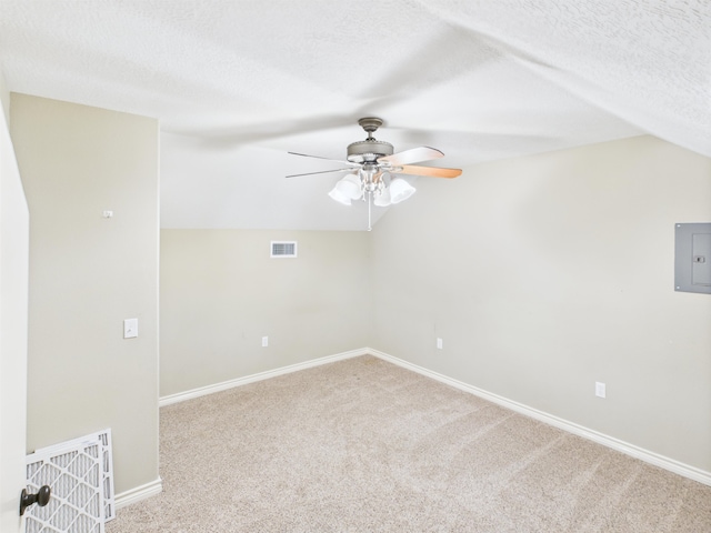 7090 Carroll Ln, Beaumont, TX 77713 - carpeted spare room featuring electric panel, vaulted ceiling, ceiling fan, and a textured ceiling
