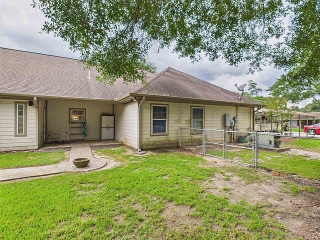7090 Carroll Ln, Beaumont, TX 77713 - back of property with a gate, roof with shingles, and an outdoor fire pit