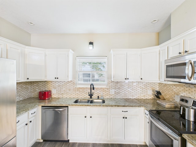 7090 Carroll Ln, Beaumont, TX 77713 - kitchen with appliances with stainless steel finishes, white cabinets, backsplash, light stone counters, and recessed lighting