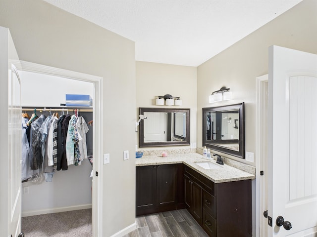 7090 Carroll Ln, Beaumont, TX 77713 - bathroom featuring vanity, a walk in closet, and wood finished floors