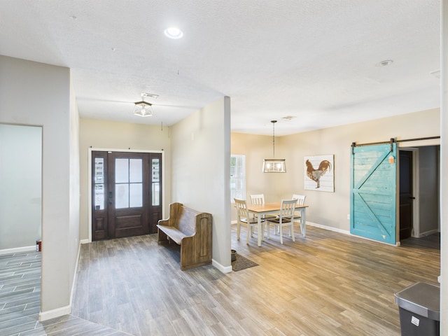 7090 Carroll Ln, Beaumont, TX 77713 - foyer entrance featuring light wood-type flooring, healthy amount of natural light, a barn door, a textured ceiling, and recessed lighting