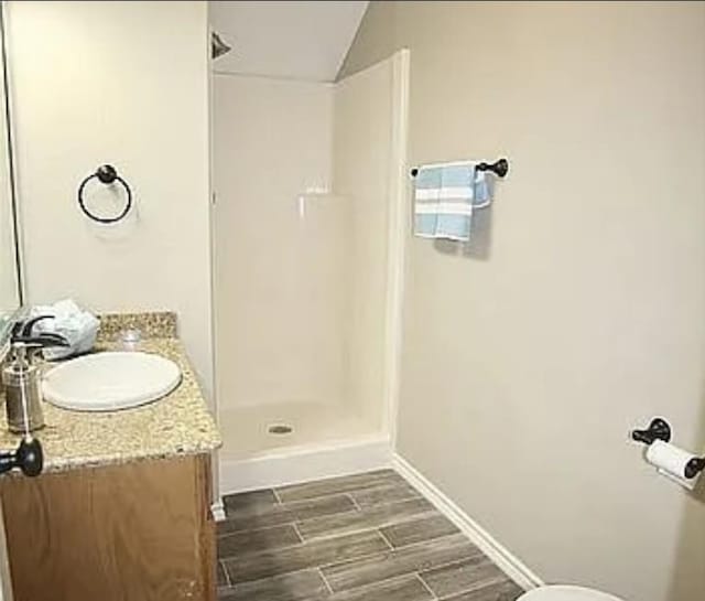7090 Carroll Ln, Beaumont, TX 77713 - bathroom with vanity, walk in shower, wood finished floors, toilet, and baseboards