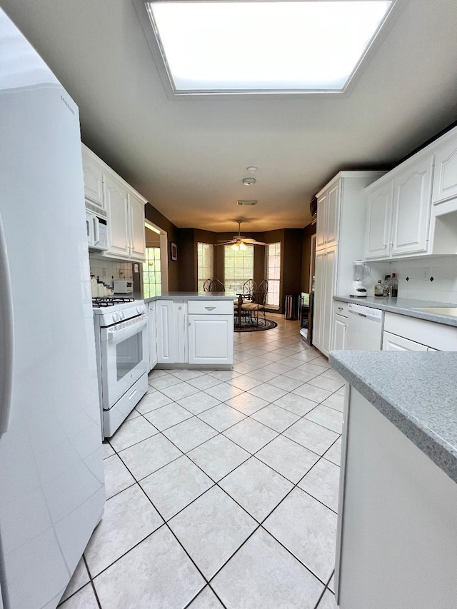 kitchen featuring white appliances, white cabinetry, and light countertops