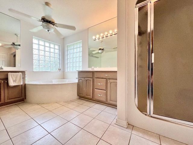 bathroom featuring tile patterned floors, a ceiling fan, a stall shower, vanity, and a bath