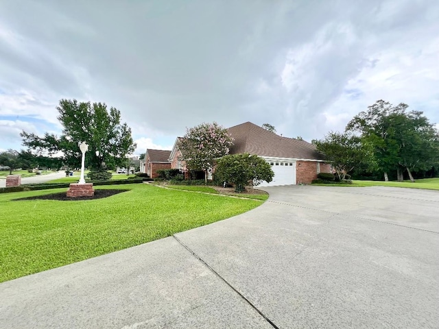 view of front of house with a garage, driveway, brick siding, and a front yard