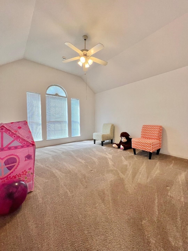 sitting room with carpet floors, ceiling fan, and vaulted ceiling