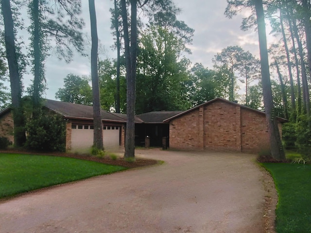 ranch-style house featuring driveway, brick siding, and a garage