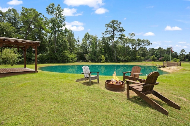 4169 Leatherwood Dr, Kountze, TX 77625 - view of swimming pool featuring an outdoor fire pit, a lawn, an infinity pool, and view of scattered trees
