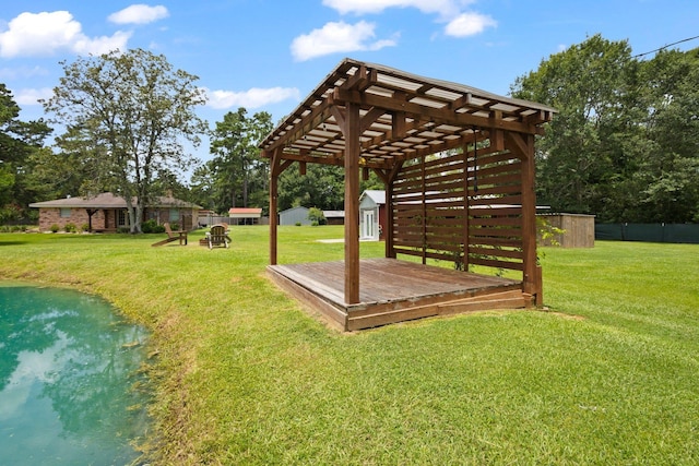 4169 Leatherwood Dr, Kountze, TX 77625 - view of grassy yard with a deck with water view, a pergola, and a storage shed