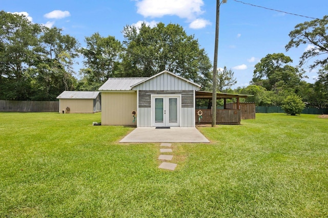 4169 Leatherwood Dr, Kountze, TX 77625 - back of house with french doors, a patio, and an outbuilding