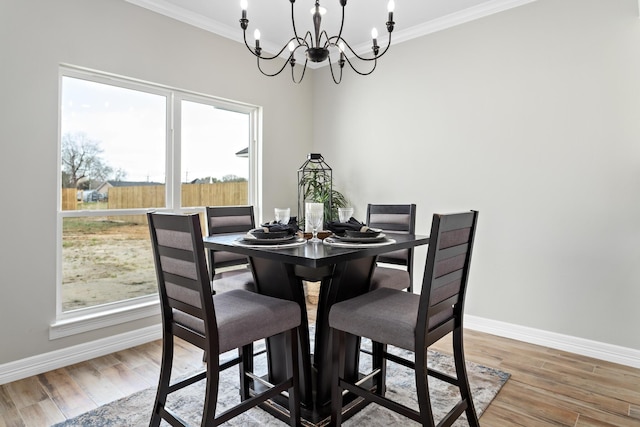 dining space featuring a notable chandelier, hardwood / wood-style flooring, and ornamental molding