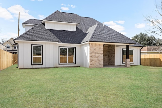 rear view of house featuring a lawn