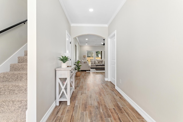 corridor with light hardwood / wood-style flooring and ornamental molding