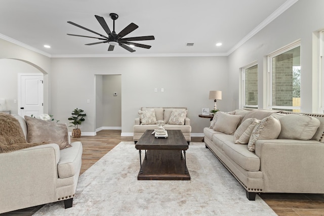 living room featuring ceiling fan, ornamental molding, and wood-type flooring