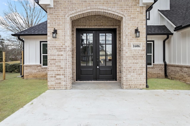 entrance to property with a lawn and french doors