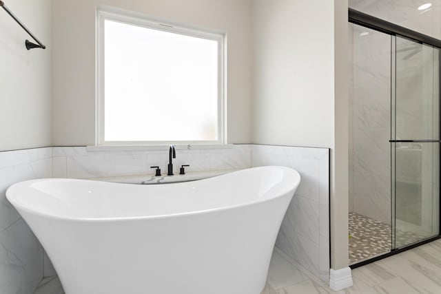 bathroom featuring separate shower and tub and tile walls