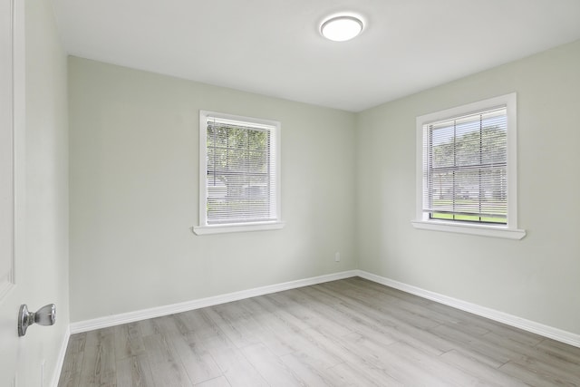 spare room featuring a healthy amount of sunlight and light hardwood / wood-style floors