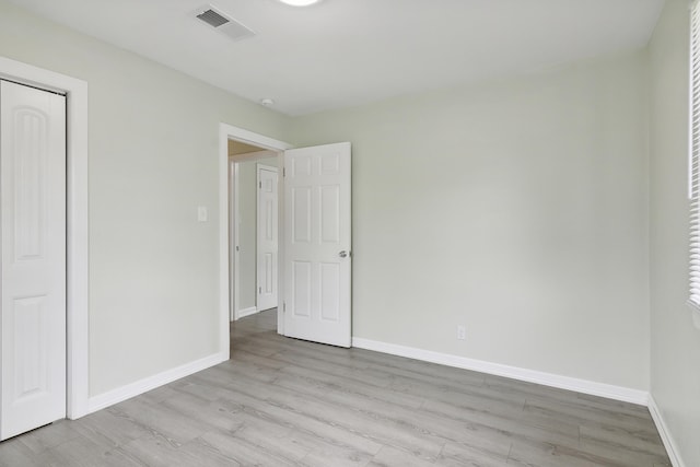 unfurnished bedroom featuring a closet and light hardwood / wood-style flooring